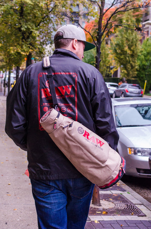 Man walking wearing a RAW Coaches Jacket and RAW Cone Duffle Bag in Canada