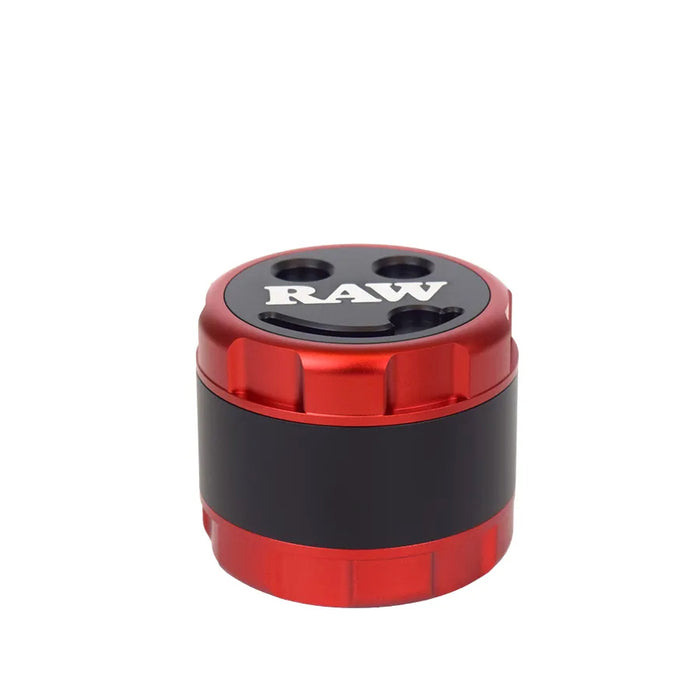 RAW brand modular steel pusher mill grinder shown with its red and black cylindrical container, open lid, inner chamber, and two silver metal milling plates